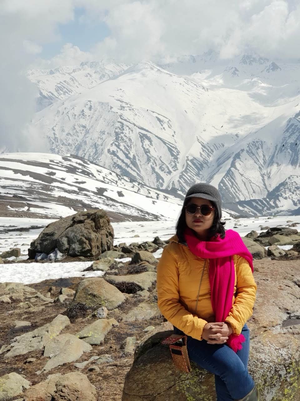 Traveller finding stillness in snow-clad mountains during a solo journey
